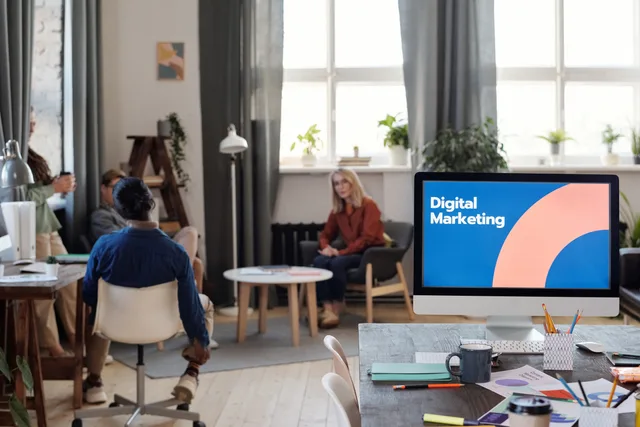 A diverse team engages in a digital marketing meeting in a stylish office setting. Do you need a paid social retargeting agency in the UK?